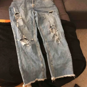  - Ett par skitsnygga slitna blå jeans i storlek medium, passformen skulle jag nog säga är man jeans / boyfriend jeans