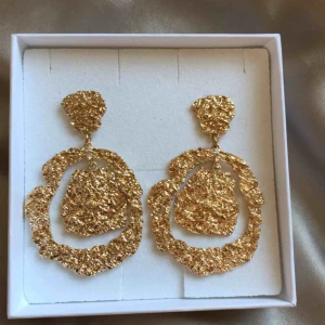  - Örhängen i guldimitation från MQ. Använda en gång. 