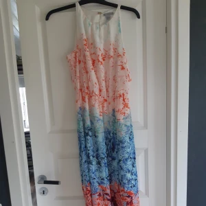  - Jättefin långklänning med blommigt mönster som går över i olika färger. Perfekt till ett bröllop eller skolavslutning.  Finns i Kristianstad eller kan den fraktas då köparen står för frakten.