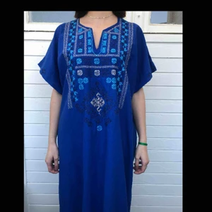  - Blå hellång kaftan/klänning med broderier. Den är i fint begagnat skick och den har inga hål eller fläckar. 100% bomull. Finns inga lappar med märket på.  Personen på bilden är 158 cm och kaftanen går ner till fötterna. 