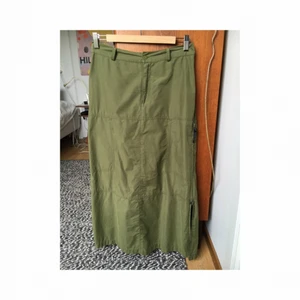  - 90-talskjol i prassligt material, tänkt att sitta på höften eller just ovanför. 