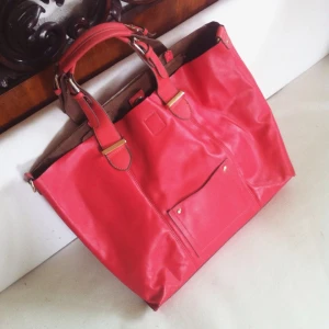  - Rosa/röd väska, skänker bort den då den har några märken på baksidan. Går bort en aning med tvätt. Frakt betalas av köpare.