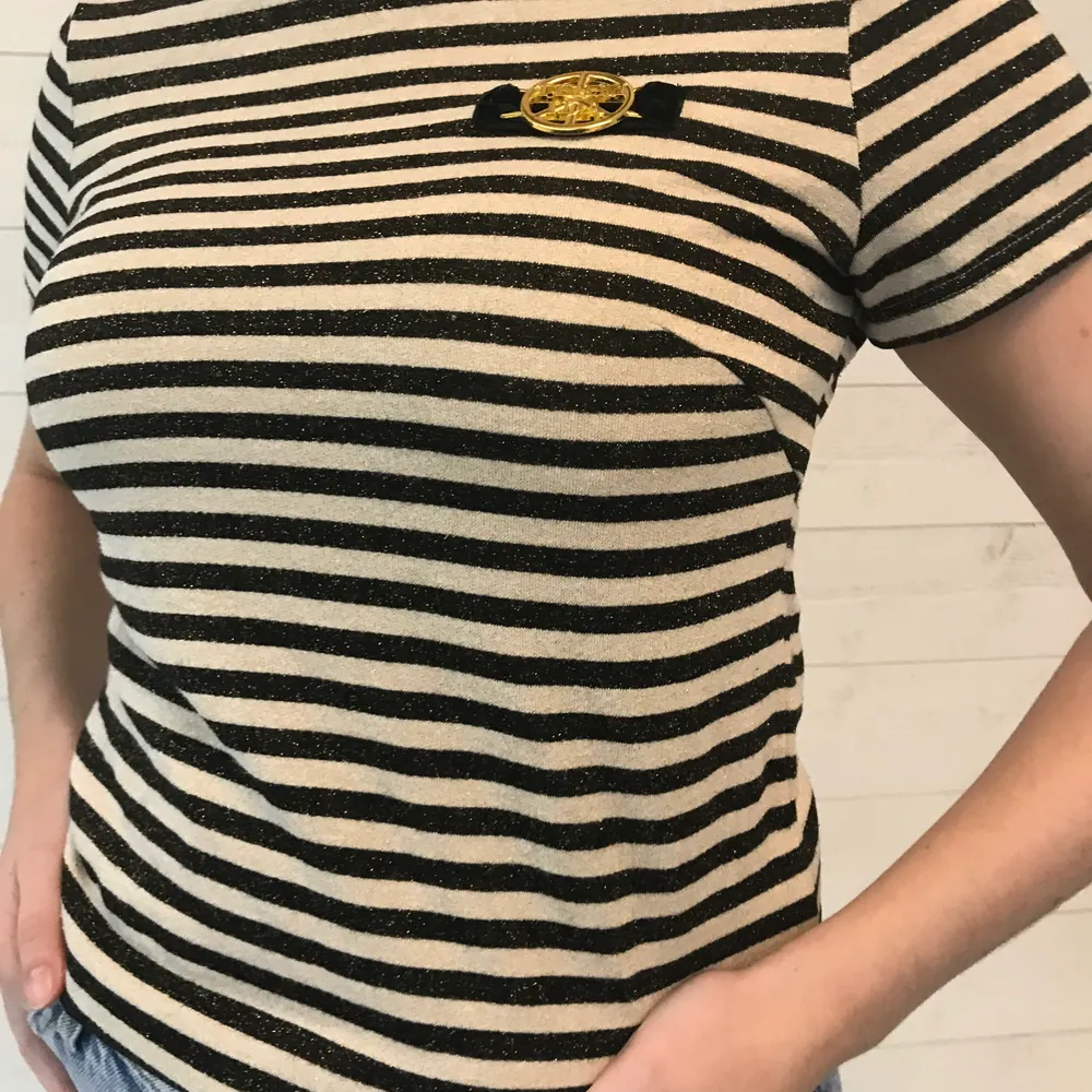 Randig t-shirt från Ida Sjöstedt. Tröjan är guldglittrig och har en detalj med ett guldsmycke där det står ”TEAM IDA”. Storlek 38! Frakt tillkommer💓. T-shirts.