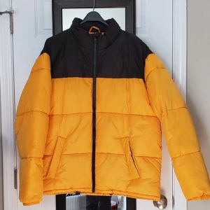 Gul och svart puffer jacka - Är i nyskick, använd några gånger bara. Påminner om Northface jackan,dock ingen luva. Skriv gärna om ni undrar något! (Manlig storlek)(två första bilderna är lånade)