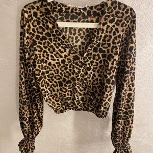 Blus med leopardtryck - Blus med leopardtryck i storlek 36. Den har en v-ringning vid brösten och långa ärmar med fransiga manschetter vid ändarna. Använd fåtal gånger. Ordinarie pris: 249kr🌸 