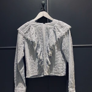 Volangblus - Ljusblå volangblus som är lite croppad, aldrig använd. Storlek 36