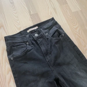 Levis Mile High Superskinny strl 24 - Grå/svarta jeans från Levis i modellen Mile High Superskinny, storlek 24 vilket motsvarar en XS. Byxorna är endast använda någon gång, kan fraktas om köparen står för frakt.