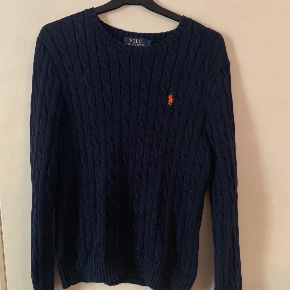 Marinblå kabelstickad tröja från Ralph Lauren i nyskick i storlek 14-16 år (L) , säljas för 100kr +frakt, inköpt för 1200kr. Stickat.