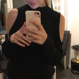 Svart stickad tröja - Jätteskön stickad tröja med öppningar vid axlarna! Är i bra skick och använd ett fåtal gånger. Frakt ingår i priset!☺️