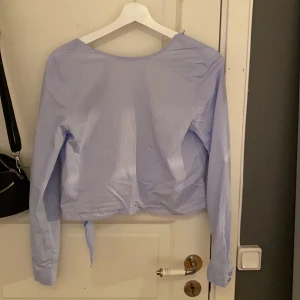 Skjorta/topp  - Säljer min tröja från NA-KD, det är en jätte fin skjort aktig topp med öppen rygg.