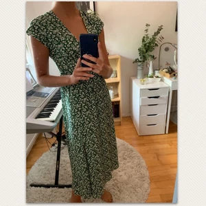 Blommig klänning  - Grön blommig klänning från topshop, aldrig använd! Öppning i ryggen och v-ringad framtill, storlek 38, vekligen supersöt klänning!