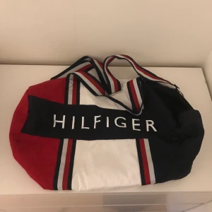 Tommy Hilfiger väska - Superfin och stor Tommy Hilfiger väska, perfekt att använda som träningsväska. Den har lite 90-tals vibbar och passar bra till mycket😍
