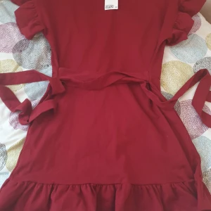 Röd klänning  - En väldig gullig röd klänning kommer ner till knäna perfekt för en fin middag ute.