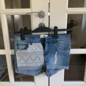  - Jeansshorts från Pieces med spetsdetalj på ena benet. Stretchig passform. 