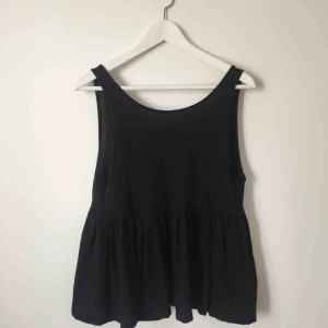  - Svart linne från Gina Tricot med markerad midja och djup rygg. Löst sittande passform. 