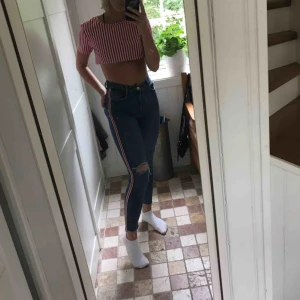 - Snygga högmidjade blåa jeans med rött sträck på sidorna. Kommer ifrån zara och är i bra skick!  Fraktas, möts upp eller byts