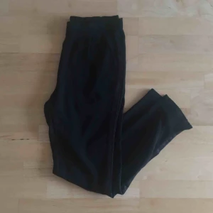  - Snygga och sköna svarta byxor! ❣️ Sparsamt använda. Med fickor och resår i midjan. Revärer i diskret glitter ✨ Passar S-M.  📬 Frakt 54 kr.