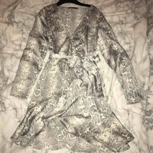 Ormmöstrad klänning  - Ormmönstrad klänning med volanger! Använd en gång🖤🖤