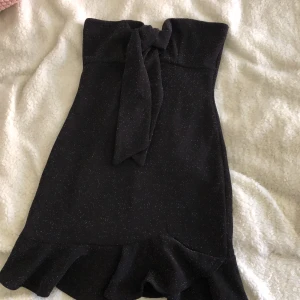 Glittrig klänning - Glittrig klänning utan band. Väldigt fint skick! Storlek 36 men väldigt liten både i form och längd. Frakt betalas av köpare.