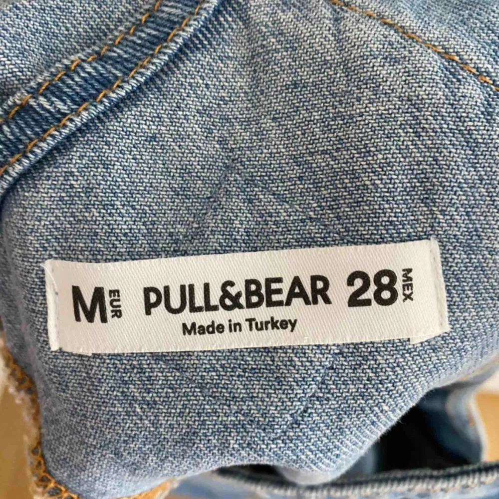 Såå snygg hängselkjol i jeans från Pull&Bear. Sitter så fint på. Slitningar längst ner längs kanten och på bröstet. Köpare står för fraktkostnad möts annars upp i Uppsala.. Klänningar.
