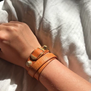 Balenciaga armband  - Säljer detta orangea Balenciaga armband. Jättensnyggt och passar vem som helst eftersom det är såpass justerbart. Detaljerna är guldiga! Startpris 500