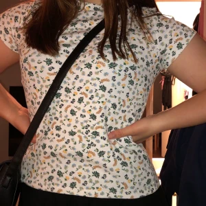 Topp - Knappt använd smått ribbad t-shirt från Monki med fint blomstermönster! Kan mötas upp i Stockholm, annars står köparen för frakt.