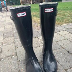 Hunter regnstövlar  - Säljer ett par äkta svarta hunter stövlar med tillhörande vita hunter strumpor. Spännerna på båda stövlarna är sönder men döljs om man väljer att använd strumporna, de har slitningar men är för övrigt hela. Därav billigt pris. Fler bilder kan skickas!