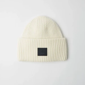 Acne mössa - Acne mössa, vit mössa med svart patch. Den är använd fåtal gånger och är i princip ny skick.