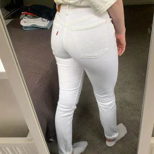 Vita levisjenas - Vita jenas från levis i modellen 501. Lädret har färgat av sig lite på byxan men på håll är det inget man tänker på. 