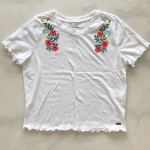 Hollister Tshirt - T-shirt med broderidetaljer från Hollister. Liten i storleken. Oanvänd! Frakten är inräknad i priset! 