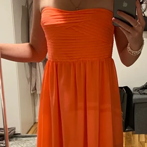 Super fin korallfärgad klänning från Vila - Klänningen är medel lång ( ner till knäna ) och är lite längre baktill. Väldigt bra skick. 400 + frakt 