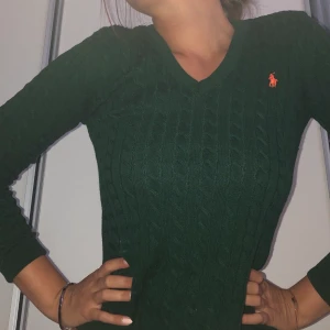 Stickad Ralph Lauren tröja  - Mörkgrön kabelstickad tröja med v-ringning. Pris inklusive frakt! 