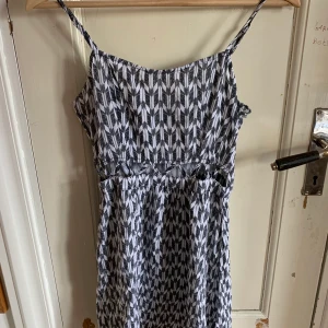 Sommarklänning med cutouts strl 34 - Klänning med cutouts. Jättebra skick förutom ett litet hål på ryggen (syns knappt). Fri frakt!