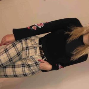  - Snygg svart tröja med utsvängda armar med blommor på.  Säljer pågrund av att jag rensar min garderob 