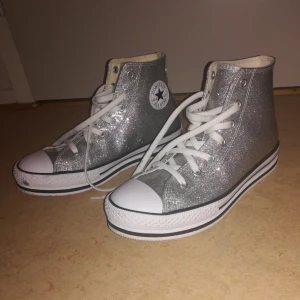  - Silverglittriga Converse i plastaktigt material med liten platå. Köptes för en månad sen för 600:- och har använts en eller två gånger sen dess. Trivs inte i dem så säljer nu vidare 😊 priset kan diskuteras. 