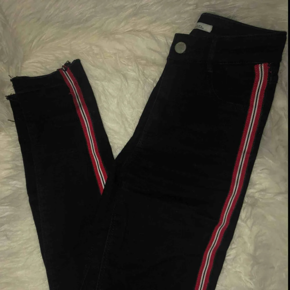 Snygga tighta högmidjade jeans med slitningar på knäna!! Röd, vit och svart revär på sidan❤️🖤sparsamt använda. Jeans & Byxor.