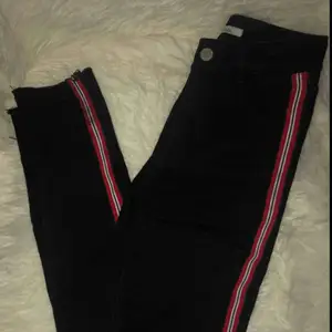 Snygga tighta högmidjade jeans med slitningar på knäna!! Röd, vit och svart revär på sidan❤️🖤sparsamt använda