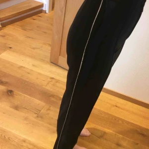  - Snygga svarta vida byxor, tighta i midjan. Frakt tillkommer 