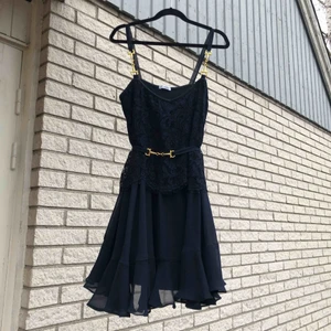  - Ida Sjöstedt Precious dress i navy storlek S.   Klänning i chiffong med spets och gulddetaljer. Isytt trikåfoder och bälte som man knyter bak. Nyskick