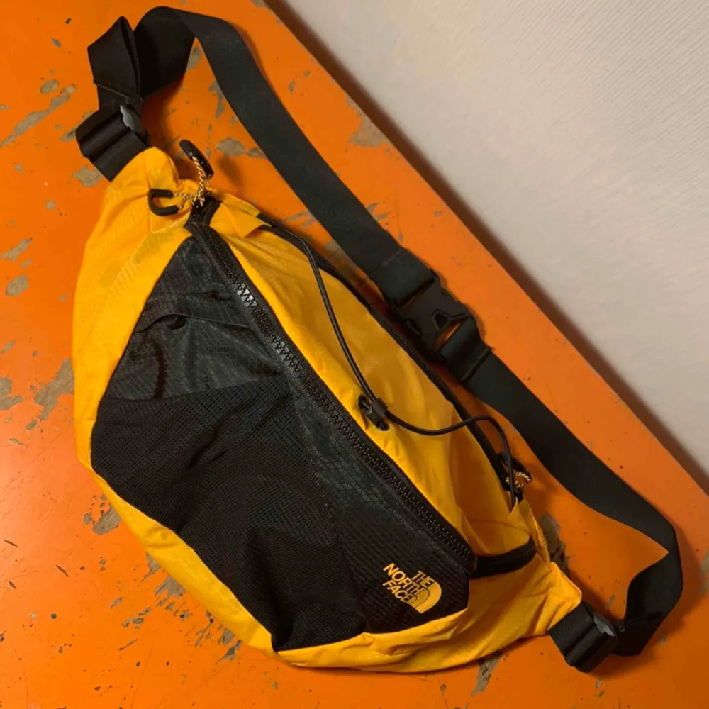 En större The North Face fannypack. Stl L, rymlig med totalt 5 fack. Fin varm gul färg med svarta detaljer. Aldrig använd, cond därav 10/10! . Väskor.