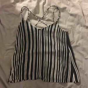  - Linne som är lite mer festligt. Randigt svart och vit med smala band. Det är lite speciellt i ryggen med kors. Skönt och somrigt🌞