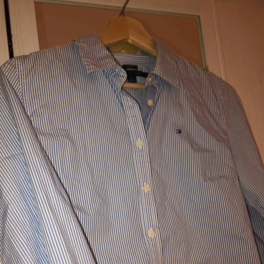 Jätte snygg och stilren blå-vit randig skjorta från Tommy Hilfiger! Jätte snygg bara sådär med jeans eller så kan man också styla med en stickad tröja över! Ttyvärr växt ur den men den är sparsamt använd✌🏼. Skjortor.