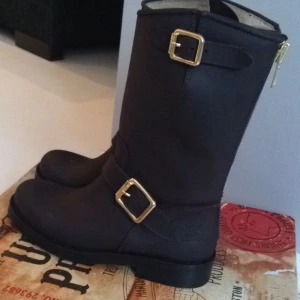  - Urban project stövlar , köpta på scorett. Mörkbruna med guld detaljer, Använda cirka 10 gånger, mycket bra skick. Impregnerade. Storlek 38 Låda finns kvar Nypris 1800:-