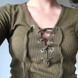  - Militörgrön ribbstickad tröja med snörning 🏕✨ nyskick! Jag bjuder på frakt