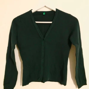  - Mörkgrön/mossgrön kofta från United Colors of Benetton. 100% ull! Svårt att fånga färgen på bild, men sista bilden visar någorlunda rättvisa. Lite 90-tal. Fint skick! XS-S