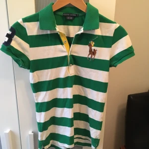  - Grön vit randig polo tröja med en svart trea på höger arm och baksidan. Bra skick. Storlek S. Mötas innanför tullarna eller köpare betalar frakt. 