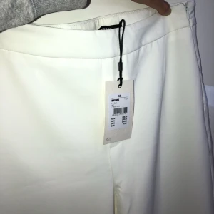  - Aldrig använda! Storlek XS! Långa breda vita byxor, passar perfekt till studenten eller andra festliga tillfällen. Oerhört fint material. Möts upp i Stockholm 