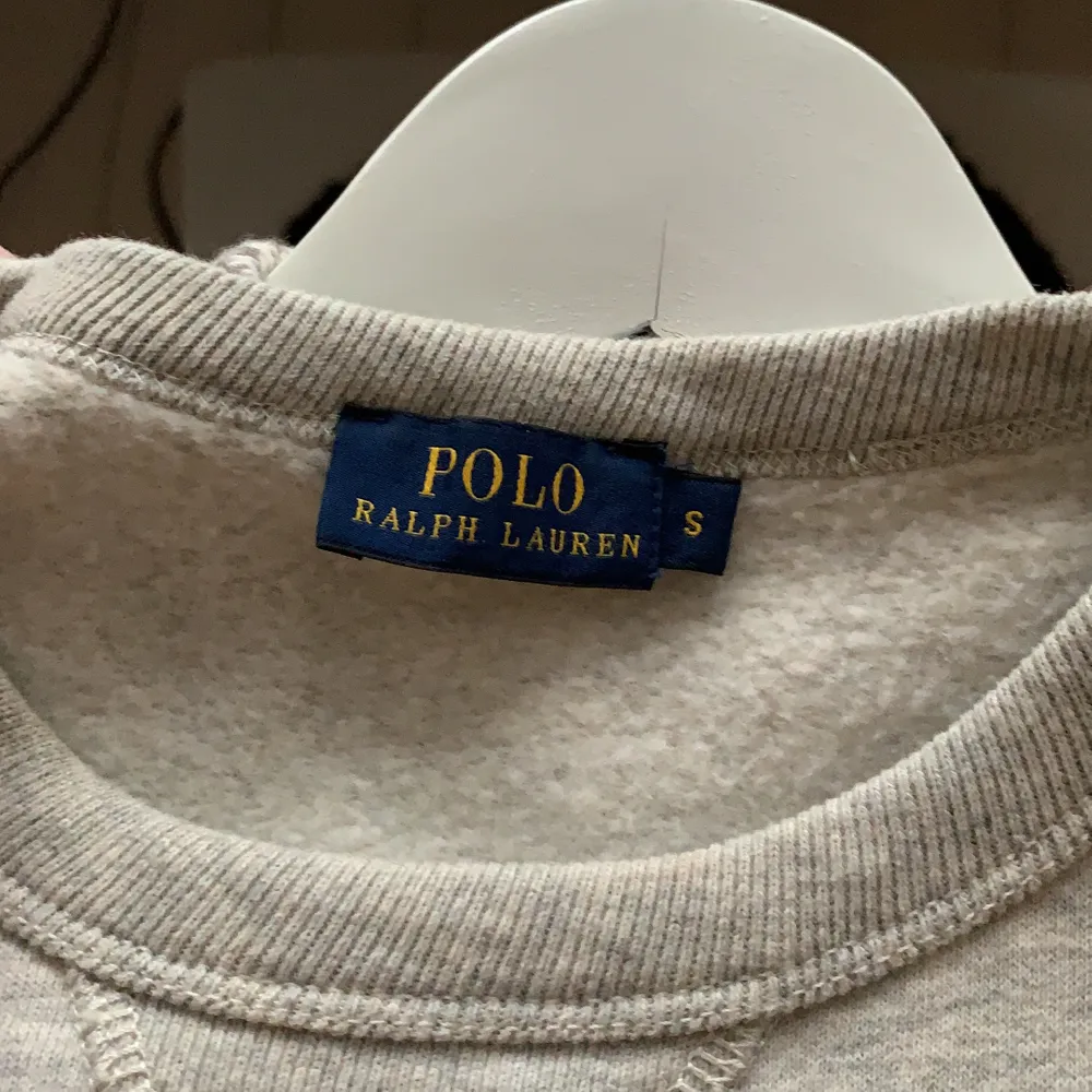 Grå Polo Ralph Lauren sweatshirt med marinblått tryck. Den är supeeeeeeer mjuk och bara använd några få gånger. Strl S men passar folk mellan 160-175cm. Köpt i New York. Hör gärna av dig vid intresse, pris kan diskuteras!. Hoodies.