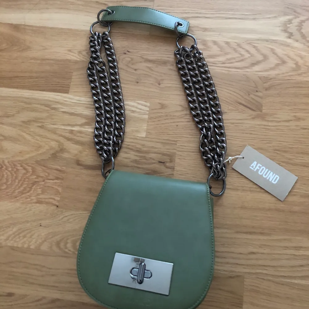 Helt oanvänd, grön NA-KD Väska med chunky chains. Väskan har en innerficka och en ytterficka på baksidan för t.ex kort. Säljes för 150kr + frakt. Laukut & Käsilaukut.