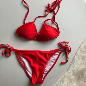 Röd bikini - Röd bikini från boohoo. Bikinin är knappt använd men väldigt fin. Överdel och underdel är i storlek S men kan justeras med knyten i nacken och på sidorna.